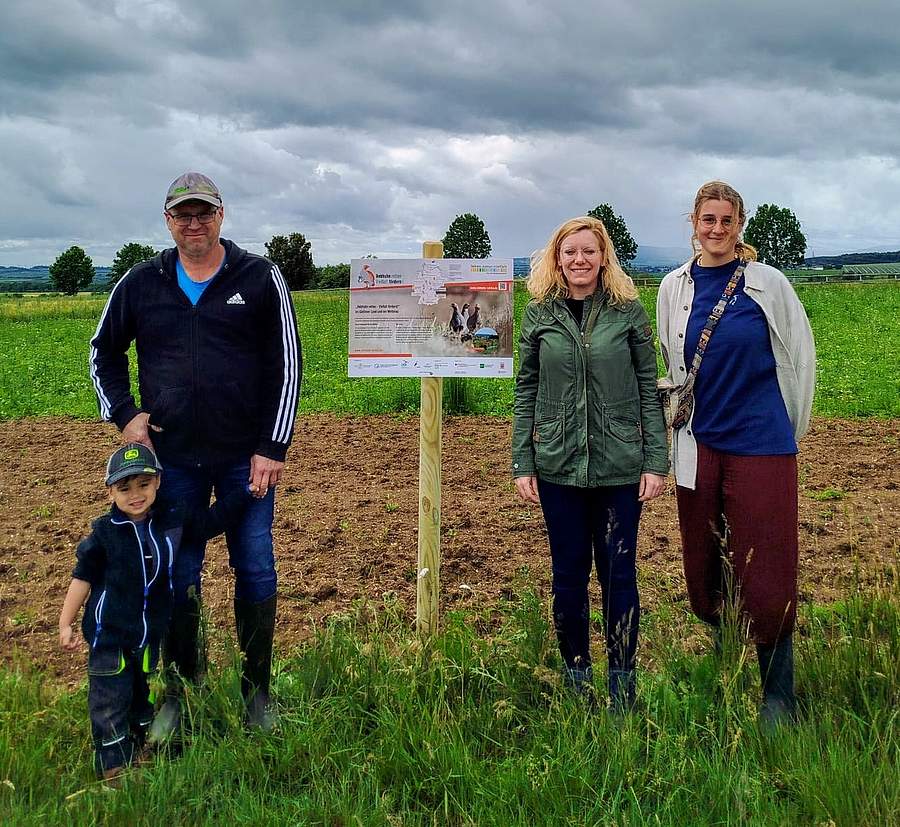 "Rebhuhn retten - Vielfalt fördern!": Ein Infoschild zum Rebhuhnschutz an einer neu angelegte Blühfläche im Projektgebiet „Gießener Land und Wetterau“ [v.l.n.r.: Landwirt Peter Grieb mit Sohn, Maike Delto (Lahn-Dill-Kreis) und Hannah Zerbe (HGON e.V.)]. Foto: HGON